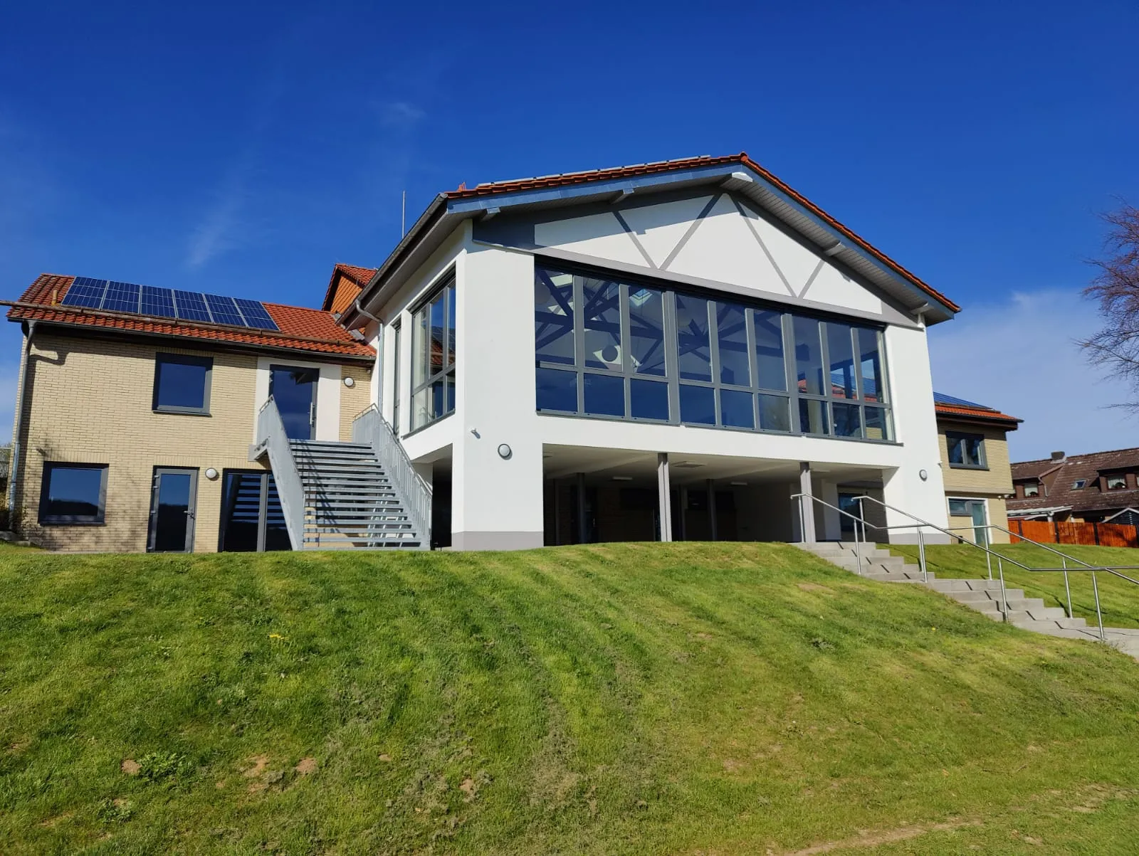 Vereinsheim mit Glasfront und Außentreppe in der Seitenansicht